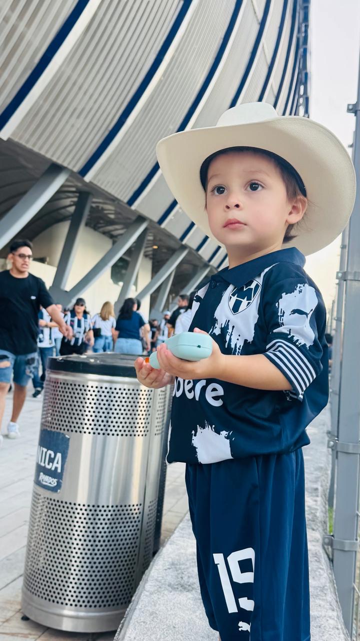 Child wearing a navy soccer kit at a stadium